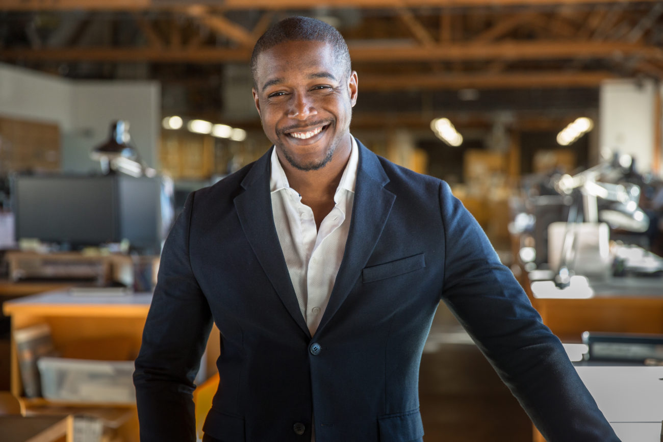 Charming successful smiling portrait of handsome african american professional in suit at office